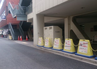 駐車場入り口横の柱の陰にあるブックポストの写真